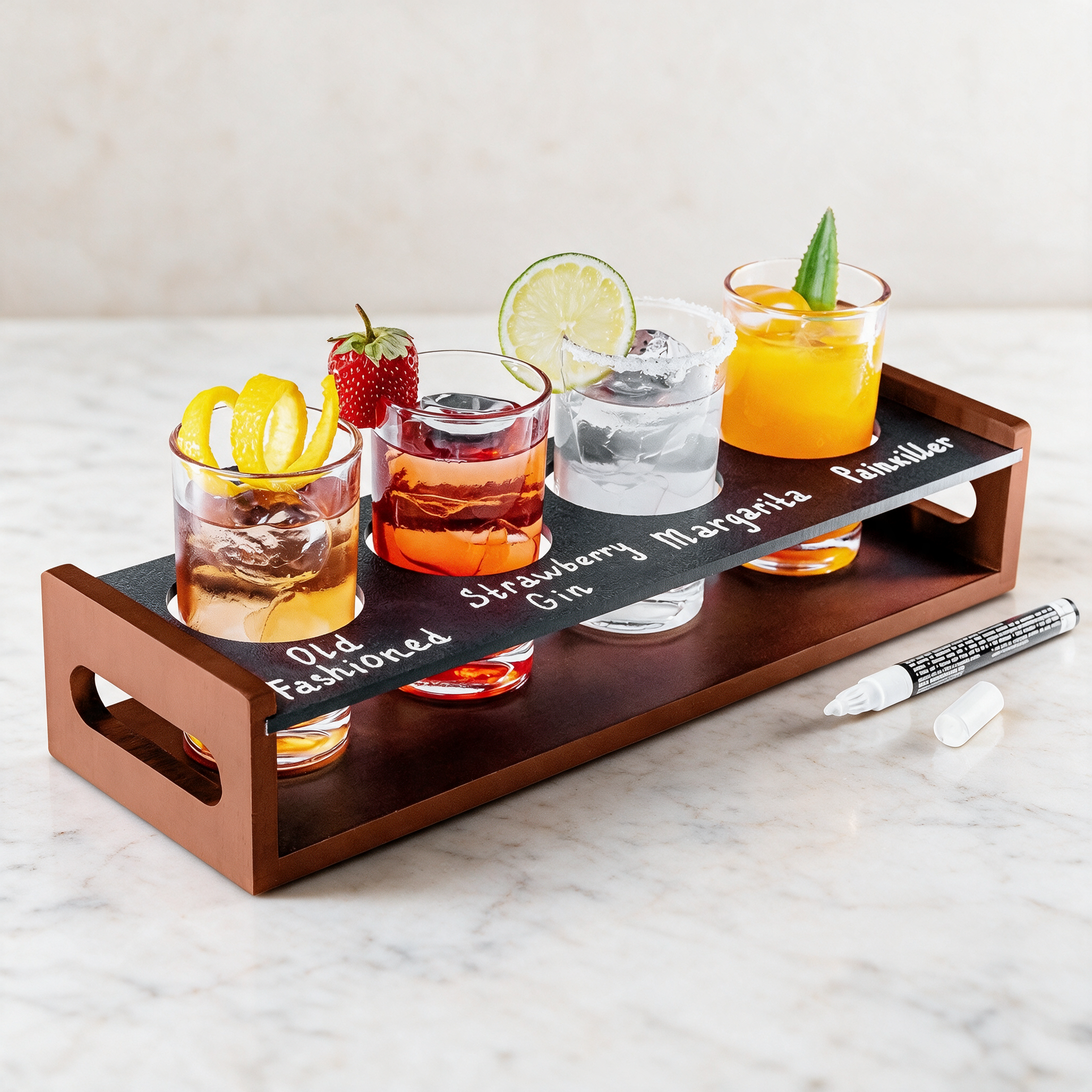 Image of KSESTOR drink flight board with four labelled cocktails and a chalk marker on a pale marble counter